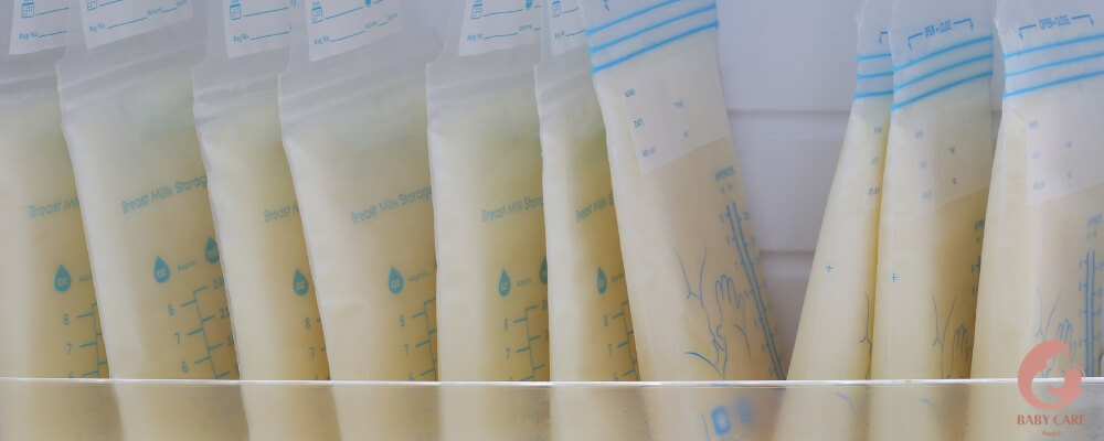 A variety of breast milk storage containers, including bags, bottles, and a silicone collector, arranged on a kitchen counter.